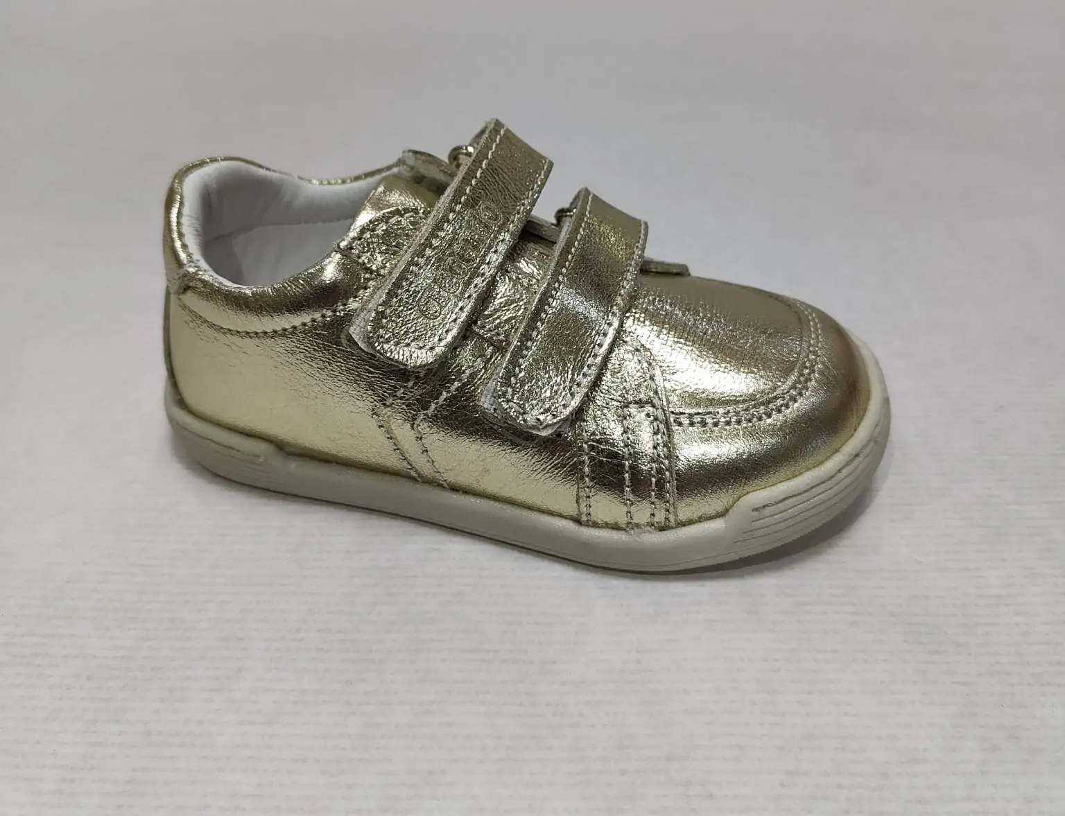 Zapato respetuoso Crescendo en piel color oro dorado, vista lateral mostrando su diseño elegante, con doble cierre de velcro y suela flexible para máxima comodidad.