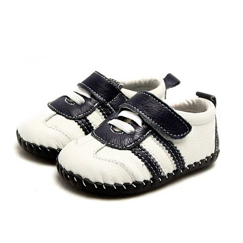Zapatillas respetuosas bebé Freycoo en blanco con detalles en negro, fabricadas en piel suave y flexible.