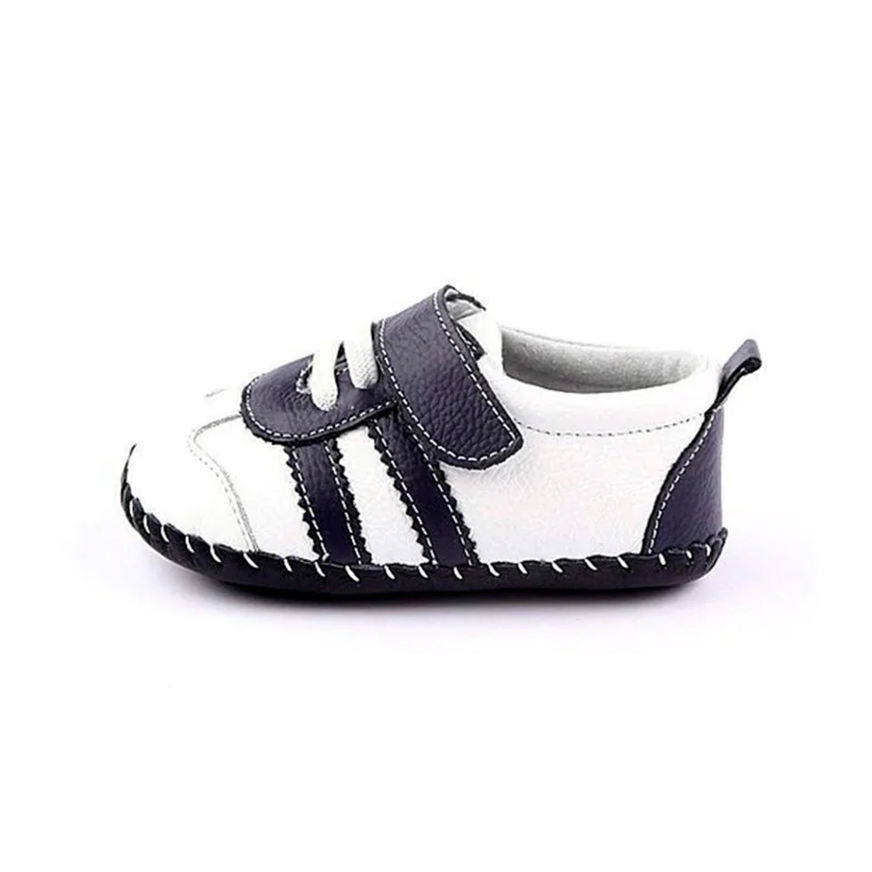 Vista lateral de zapatillas respetuosas bebé Freycoo blancas con suela flexible para primeros pasos.
