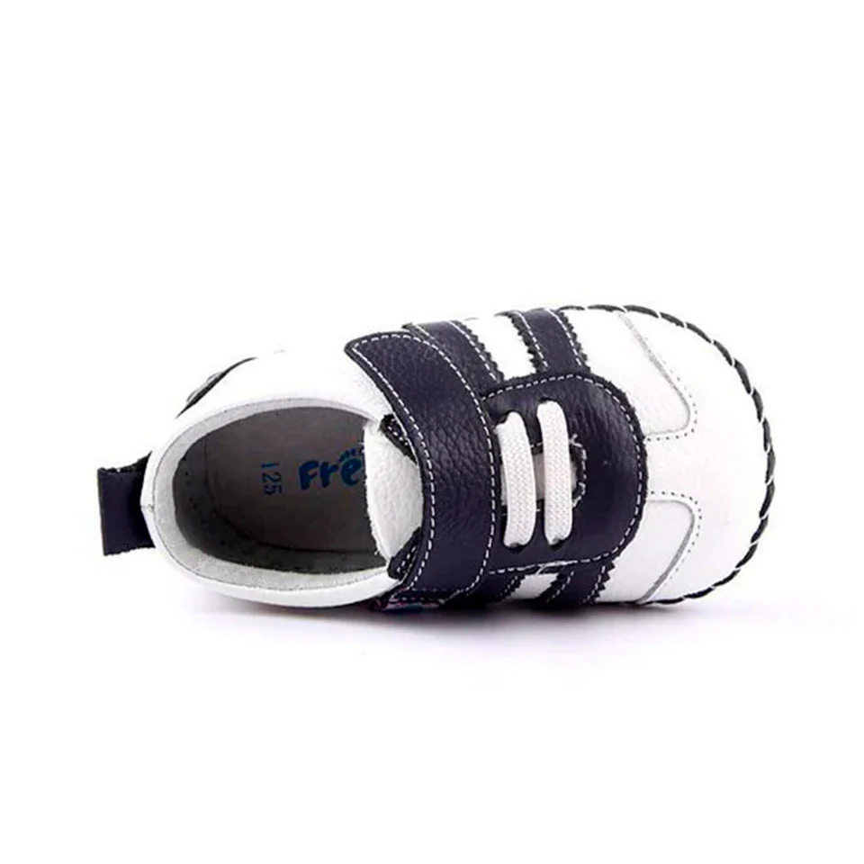Zapatillas respetuosas bebé Freycoo en blanco de piel, diseño ergonómico y cierre de velcro.